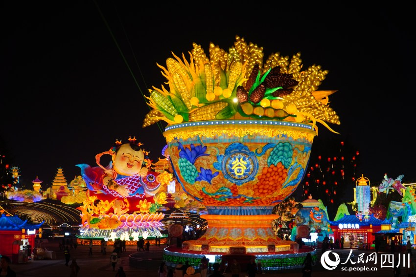 图为1月17日晚在四川自贡中华彩灯大世界拍摄的“五谷丰登”彩灯（前）和“年娃贺岁”彩灯（左后）。人民网 赵祖乐摄