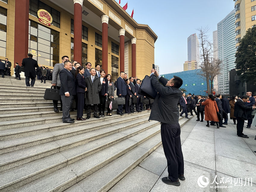 開幕式前，與會代表、委員在會場前拍照留念。人民網記者 王波攝