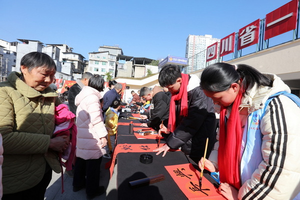 青少年书法传习者为市民现场书写春联。马发海摄