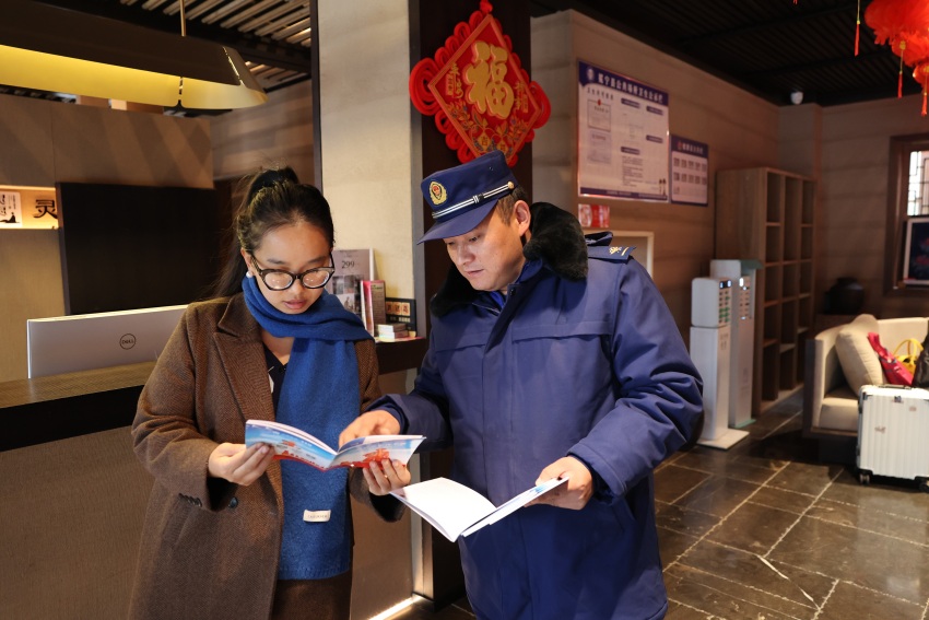 消防员正在向群众发放消防宣传单，讲解消防知识。冕宁县消防救援局供图