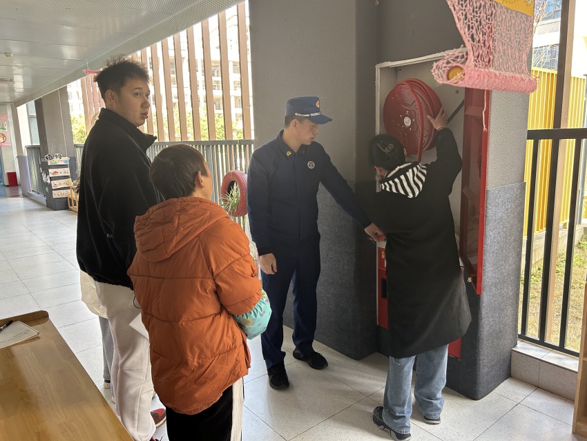 消防员正在给教职工讲解消防设施的使用方法。眉山天府新区救援大队供图