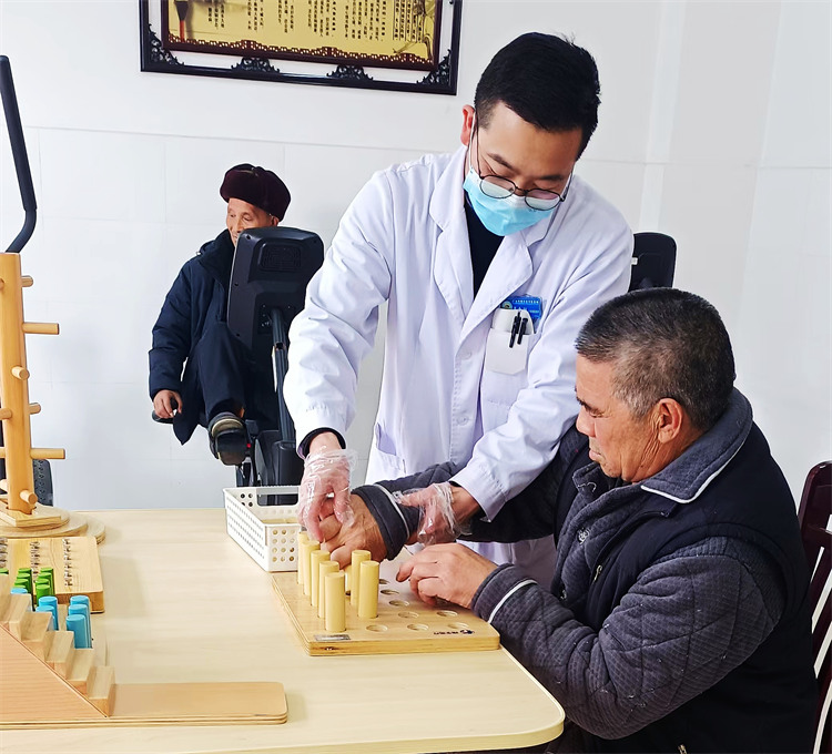 石腊春老人在医护人员的陪伴下进行康复训练。张敏供图