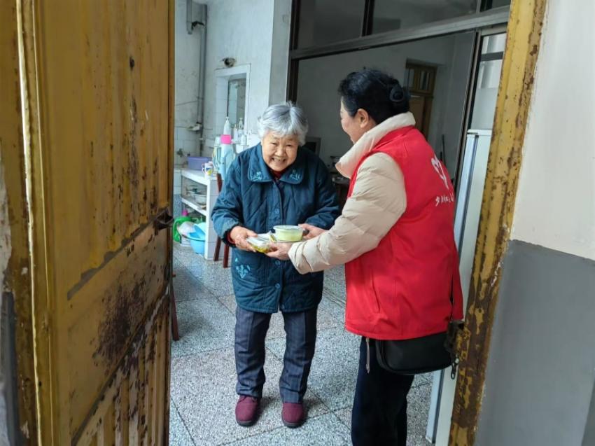 花园社区的百岁老人刘婆婆收到志愿服务队送来的热气腾腾的午餐。主办方供图