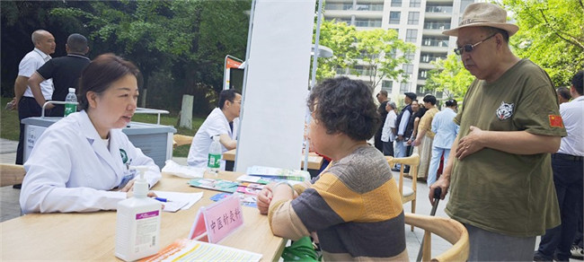 四川省第四人民医院中医针灸科主任中医师、四川省名中医陈敏正在给前来义诊的80岁社区居民朱爷爷夫妇耐心诊疗病情。四川省第四人民医院供图