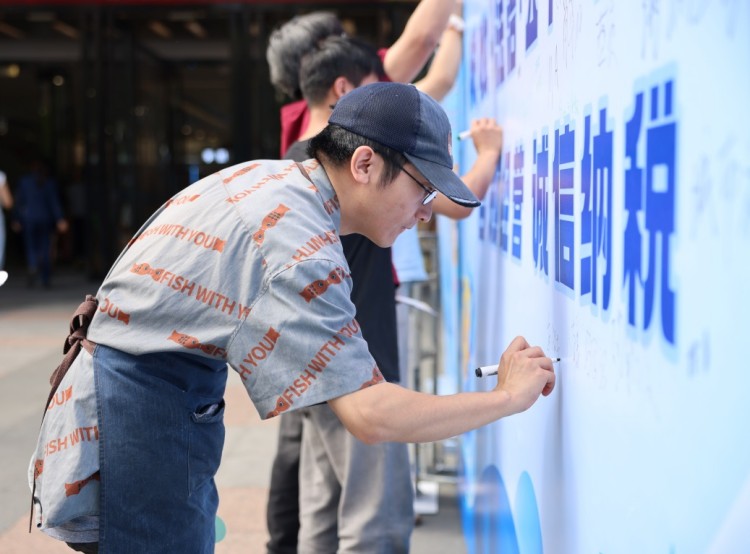 商家在诚信纳税墙上签名。攀枝花市税务局供图