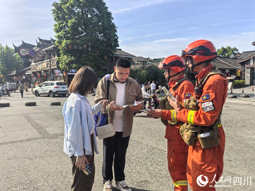 5月1日，都江堰景区，消防员唐平、谭弋飞正在进行防火宣传。程雪力摄