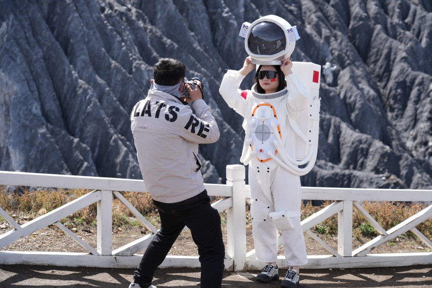 游客身着太空服，在墨石公园“星际穿越”主题打卡点拍照。道孚县委宣传部供图