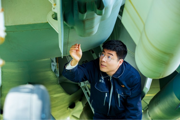 冯攀龙指着自己参与制造的高端航空装备模型机上的铆钉。受访者供图