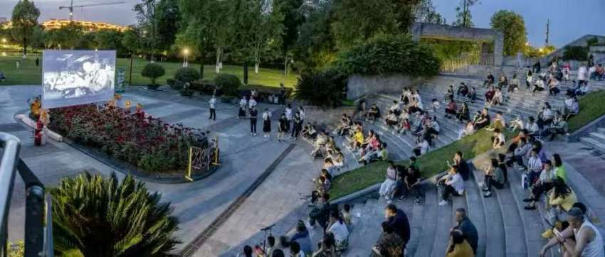 东坡城市湿地公园，市民游客驻足观看坝坝电影。侯建明摄