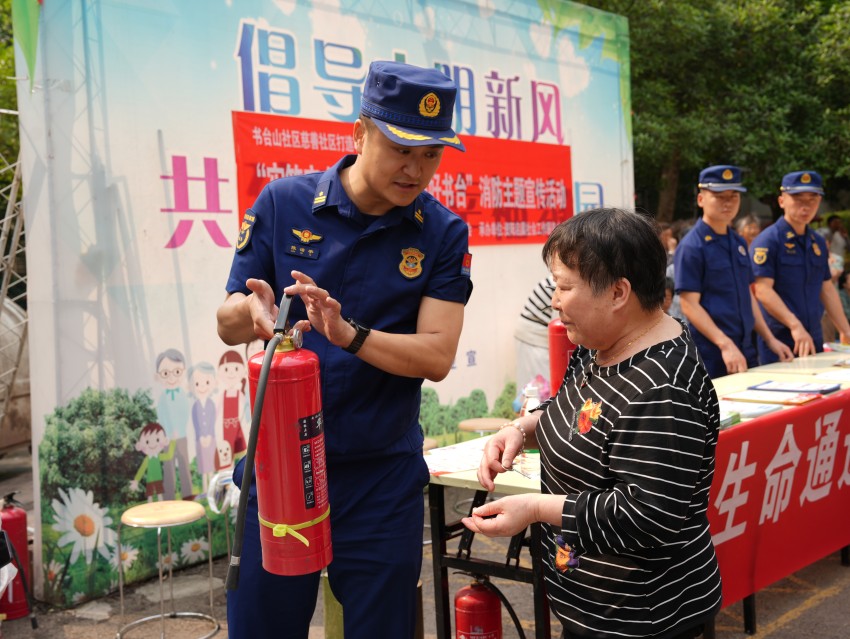 消防救援人员向居民演示灭火器的正确使用方法。资阳高新技术产业园区消防救援大队供图