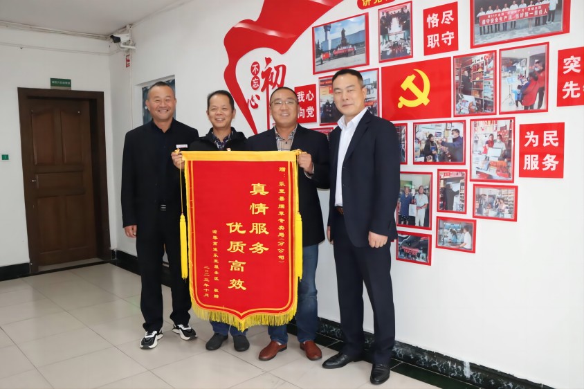 客户为池世兵（左二）送上锦旗。乐至县烟草专卖局供图