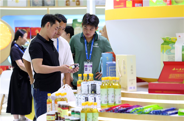 参展人员观看广安展台的展品。康建林摄