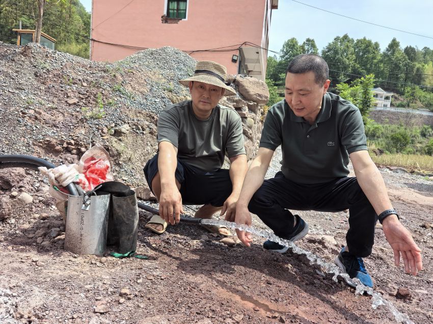 陈明华（右一）查看地下取水情况。万源融媒体供图