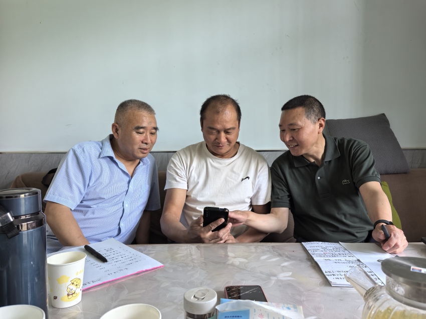 陈明华（右一）向村民宣讲政策。万源融媒体供图