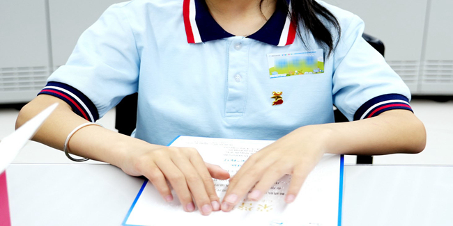 小朋友触摸活动证书上的盲文。成都轨道集团供图