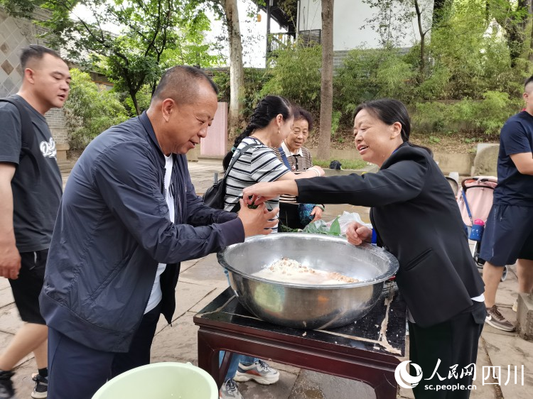 工作人员正在指导游客包粽子。李建生摄