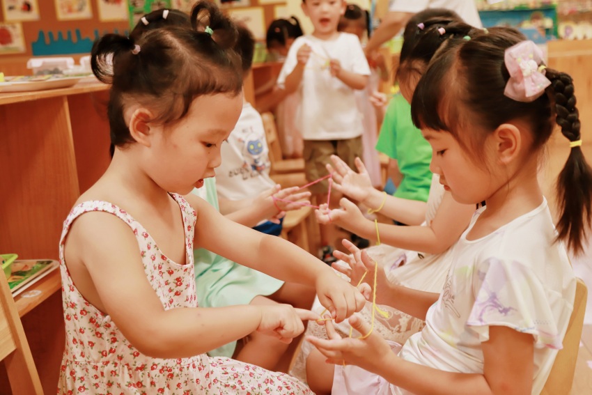 孩子们在玩翻花绳游戏。成都市第三幼儿园528园区供图 