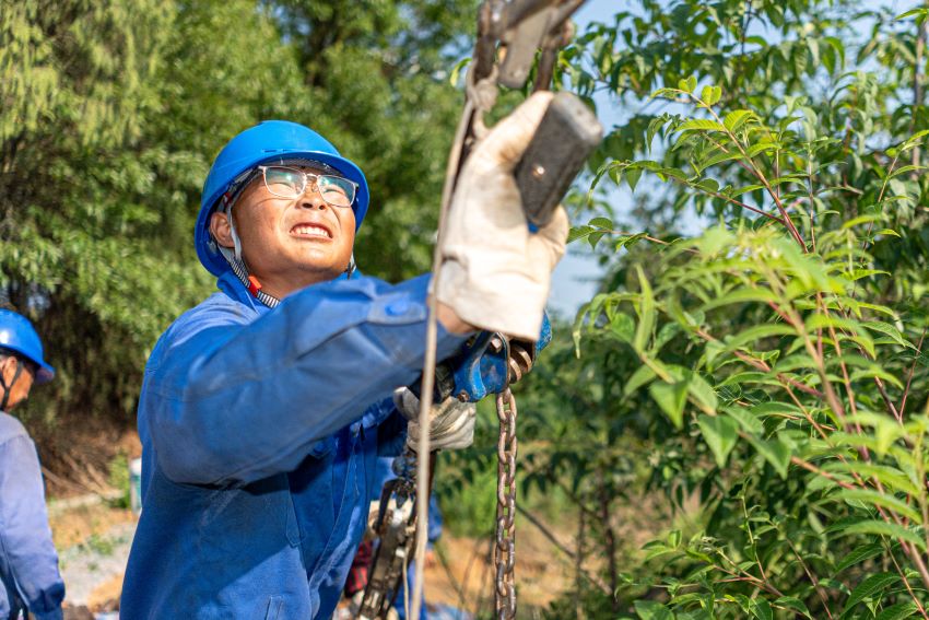 国网绵阳供电公司员工在220千伏盐亭输变电工程线路作业现场调紧拉线。 田海摄