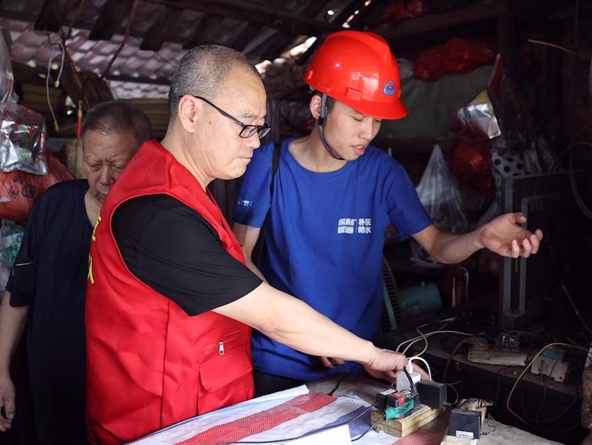 志愿者为失孤老人零售户排查电源隐患。何亚卓供图