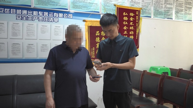 郭佐軍（右）向乘客肖某（左）返還多付的9843元車費。艾蘭花攝