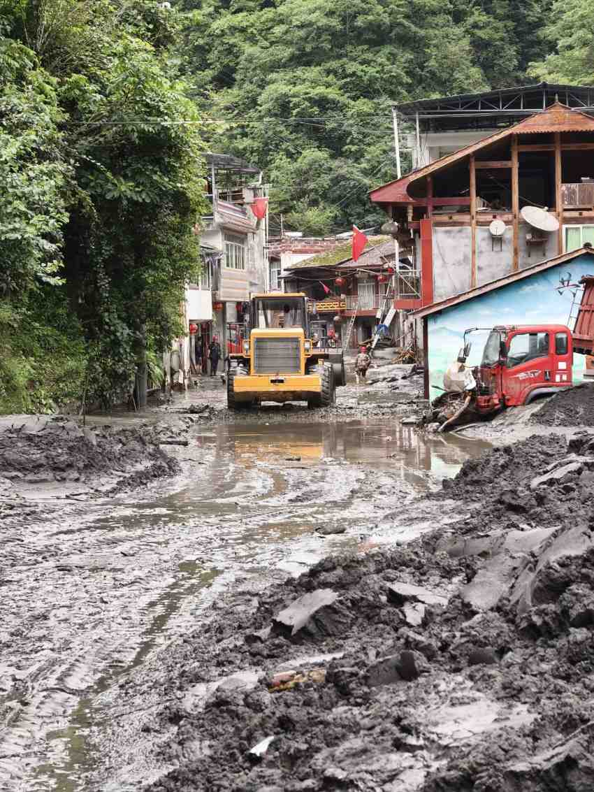洪水退去后，搶險隊員深一腳淺一腳行進在搶險的路上。四川省水電集團供圖
