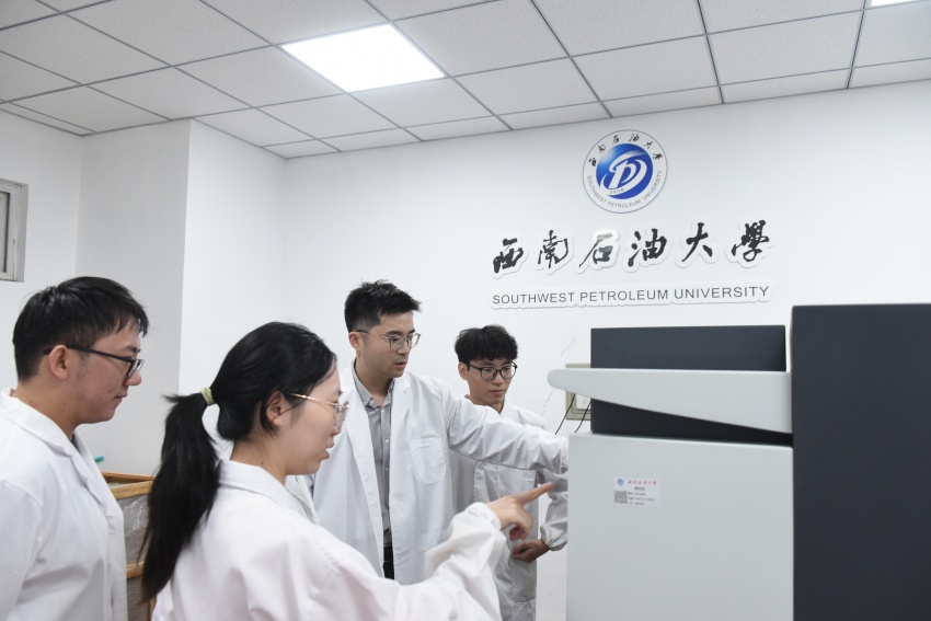 钟诚向团队学生介绍学校新引入的先进实验设备。袁唯茜摄