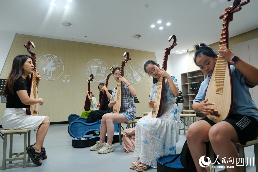 孩子们在眉山市彭山区文化馆“艺启武阳文化课堂”暑期公益培训班上学习琵琶弹奏。翁光建摄
