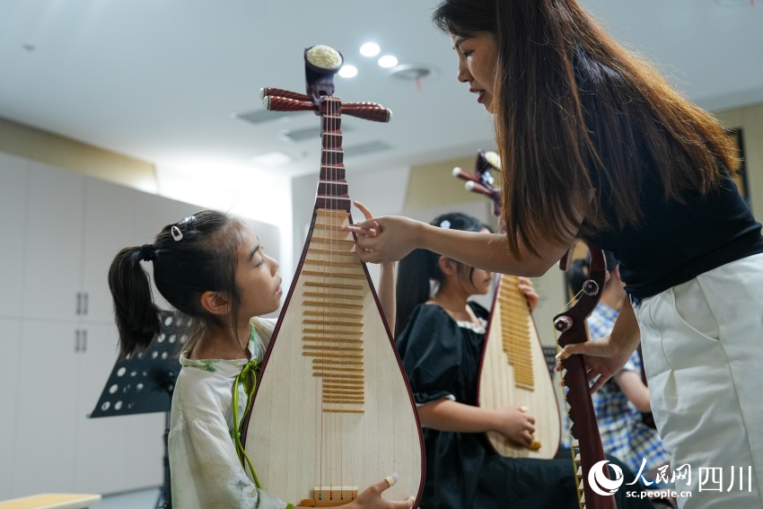 孩子们在眉山市彭山区文化馆“艺启武阳文化课堂”暑期公益培训班上学习琵琶弹奏。翁光建摄