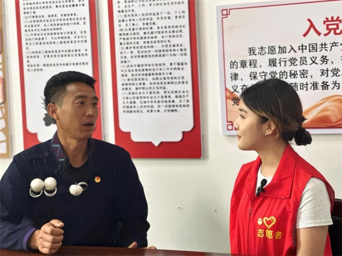 实践队员对普格县特补乃乌村书记阿比优杰进行采访。四川文化产业职业学院校团委供图