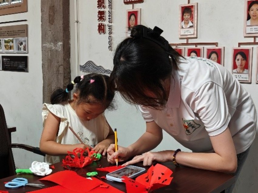 志愿者教小朋友做手工。四川旅游学院艺术设计学院供图
