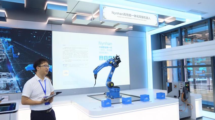 讲解员正向代表们介绍卡诺普新一代一体化高性能焊接机器人展项。成都市国资委供图