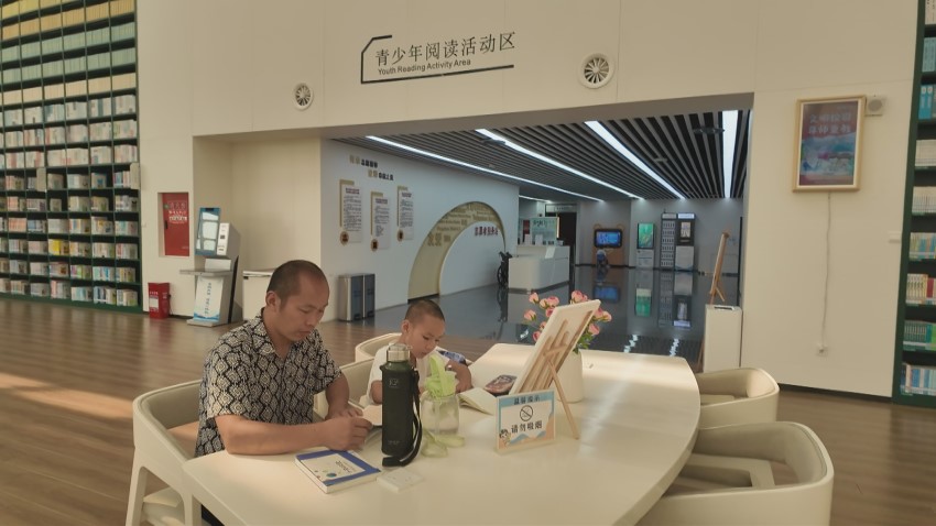 家长带着孩子在图书馆学习。周琳摄