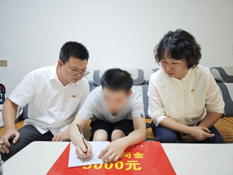 教師代表將助學慰問金交到吳同學手中。四川工程職業技術大學供圖