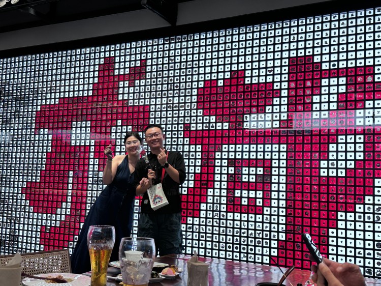 游客在熊猫徽章艺术墙打卡。刘雪峰供图