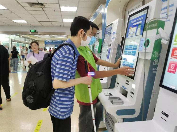 志愿者为患者及家属提供自助机操作协助。张静供图