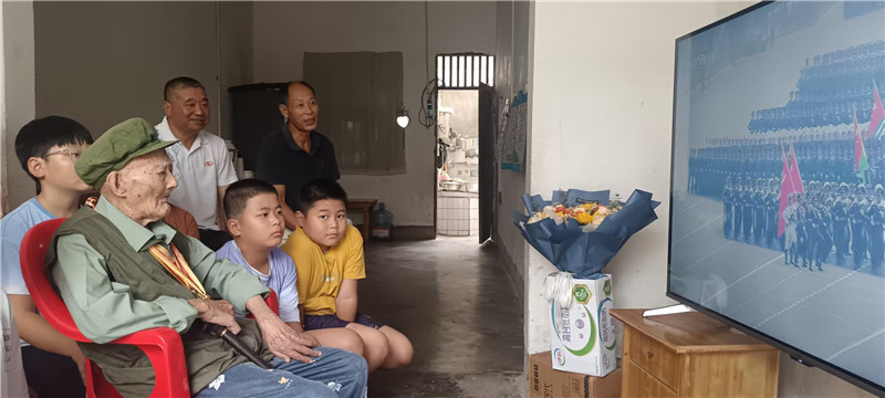 抗战老兵何远志和家人收看阅兵式。张天文摄