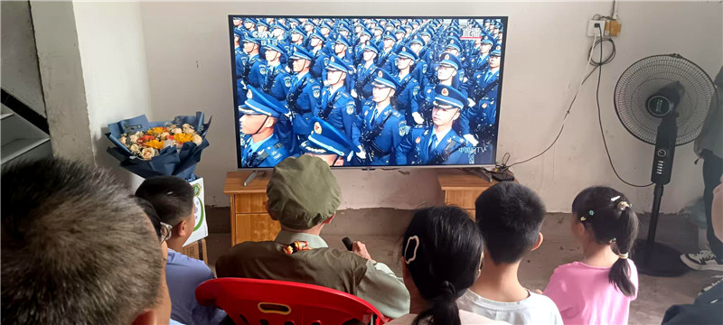 抗战老兵何远志带领家人收看阅兵式。张天文摄