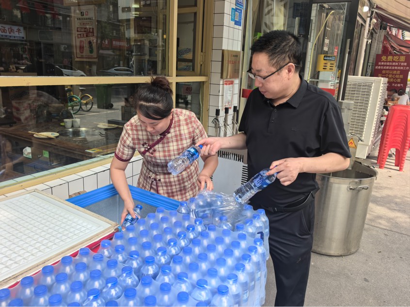 赵春燕（左）正在向“爱心冰柜”补水。受访者供图