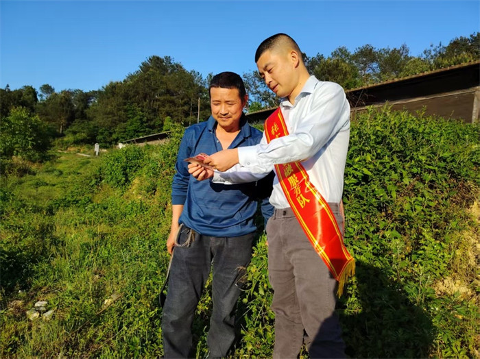 小蔣為村民講解真假鈔票的辨別要點。建行四川瀘州分行供圖