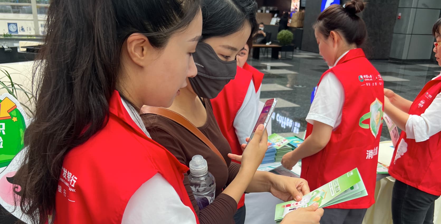 广发银行员工为市民分发活动手册。广发银行成都分行供图