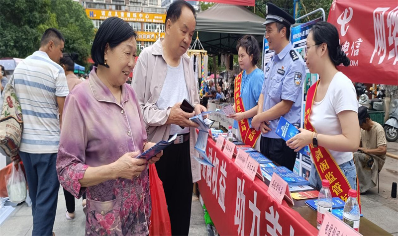活动现场为群众发放宣传手册等网络安全资料。王富民供图
