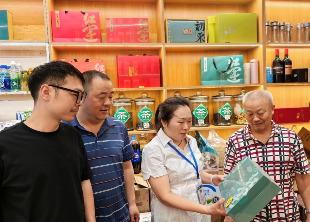 王芬在陈鹏店里帮忙介绍产品。巴州区烟草专卖局供图