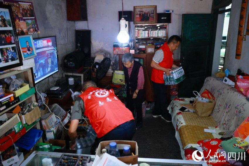 “齊樂先鋒隊”志願者幫駱舒程清理雜物。王雅竹攝