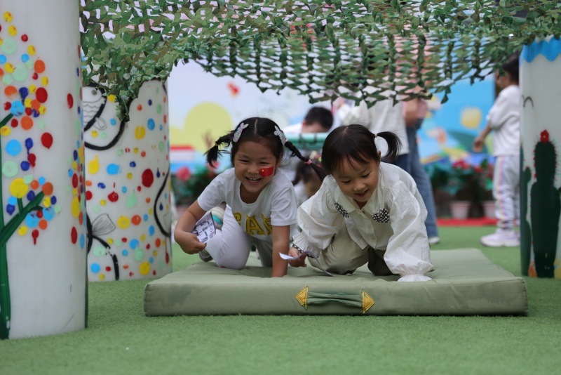 孩子们在游戏中弯腰前行，并快速通过。成都市第三幼儿园528园区供图