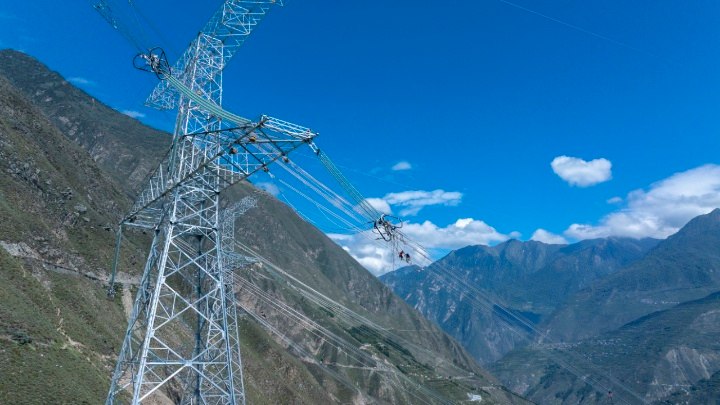 在阿坝藏族羌族自治州汶川县,作业人员正在阿坝至成都东1000千伏特高压交流输电工程14大档距跨越现场,开展紧线作业。谢春艳摄