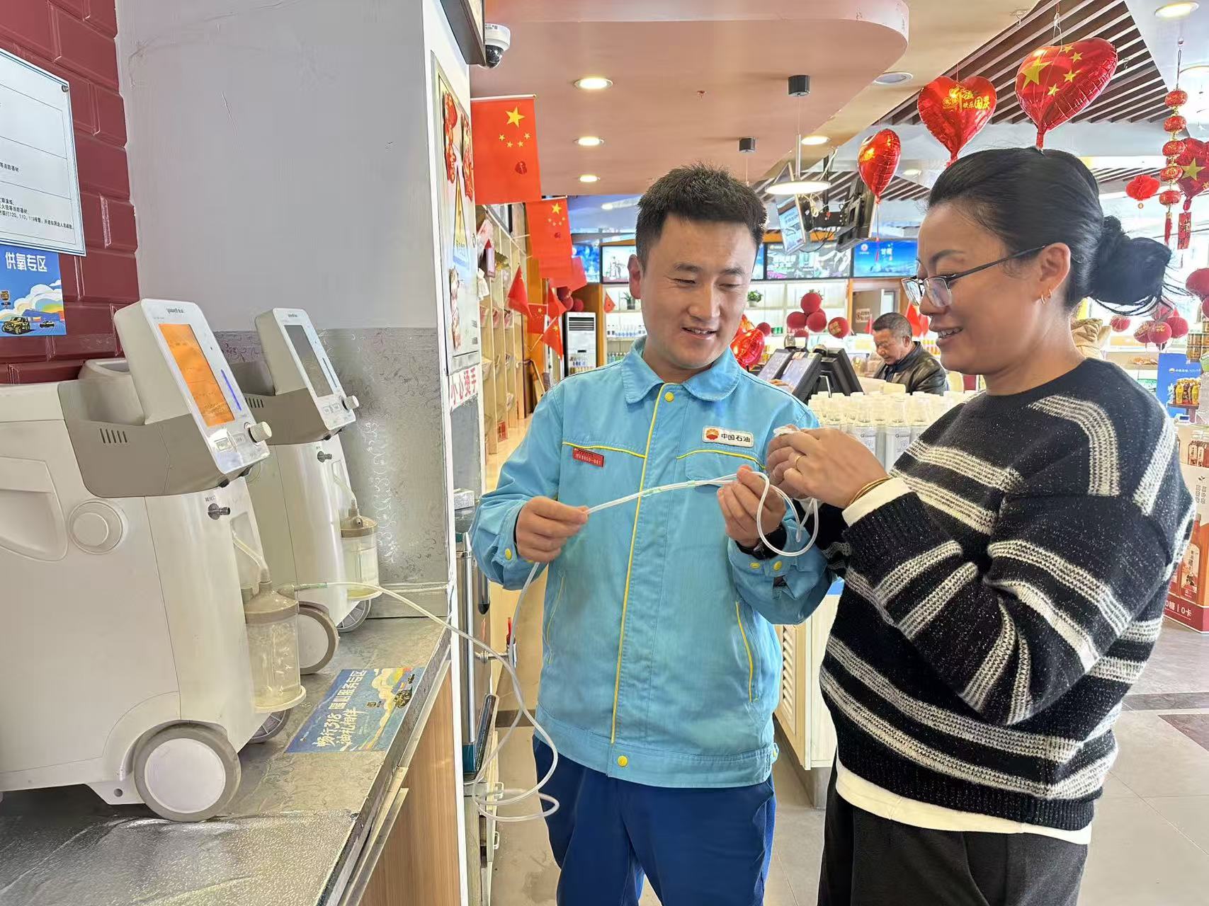 在中国石油四川甘孜销售分公司新都桥加油加气站，一名游客正在员工帮助下使用吸氧机。尼尔月拉摄.jpg