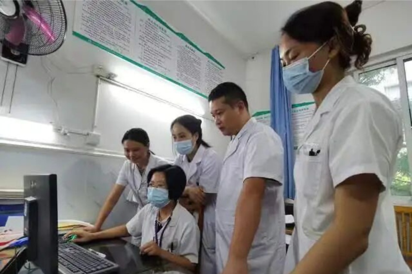 肖丽霞与同科室医生交流病情。东兴区卫健局供图