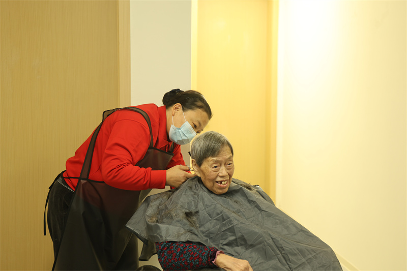 工作人员为老人理发。翠屏区融媒体中心供图
