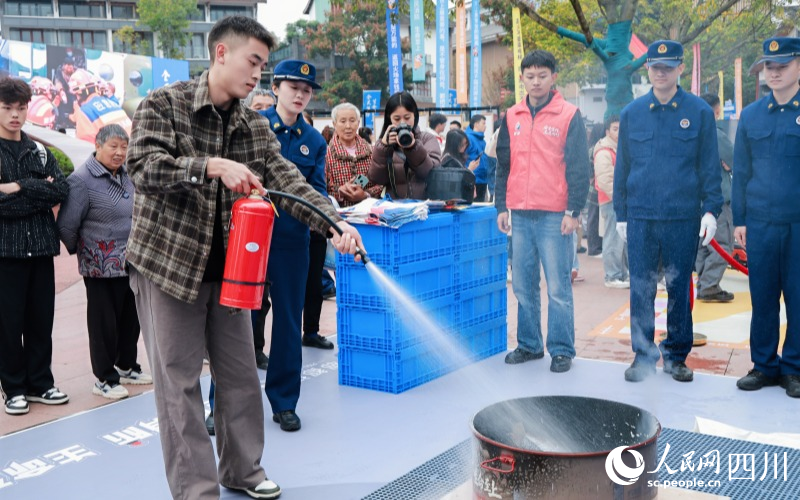 市民群眾實操滅火器滅火。實習生 鄭宇丹攝