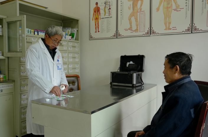 彭學軍正在為前來看病的村民配藥 陳欣 攝